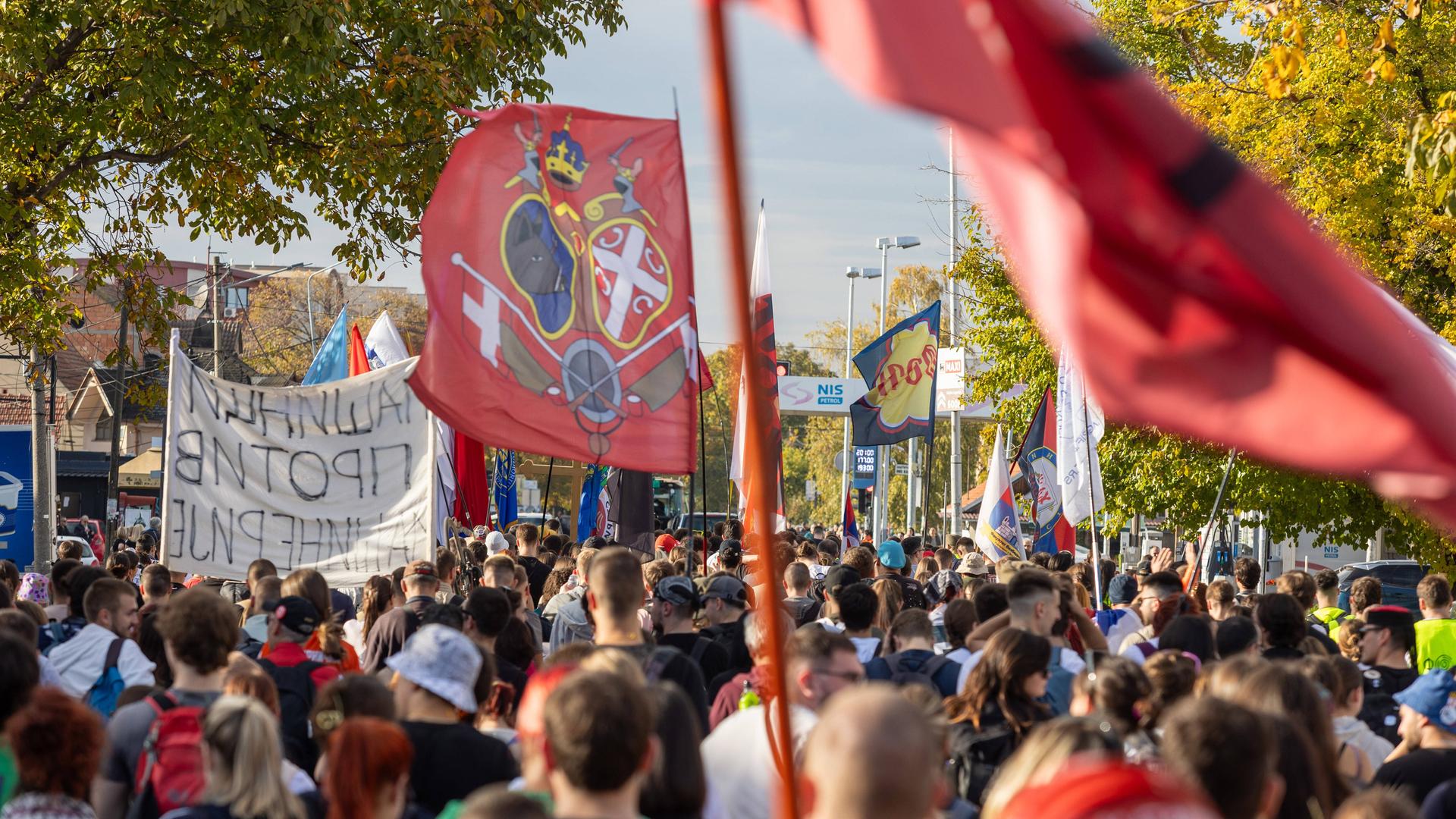 Studierende und regierungskritische Protestler marschieren mit Fahnen und Bannern am 30.10.2025 in Richtung Novi Sad, wo vor einem Jahr das Vordach des Bahnhofes eintsürzte