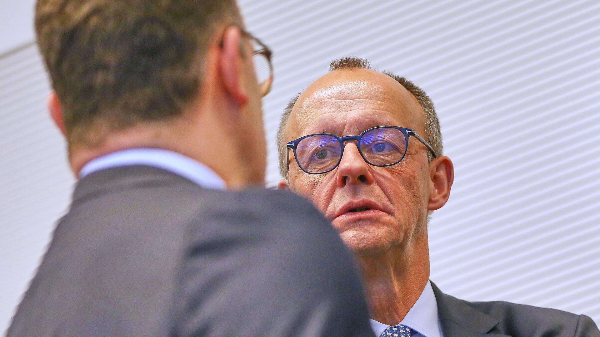 Unionsfraktionschef Jens Spahn (CDU) und Bundeskanzler Friedrich Merz (CDU) sprechen miteinander.