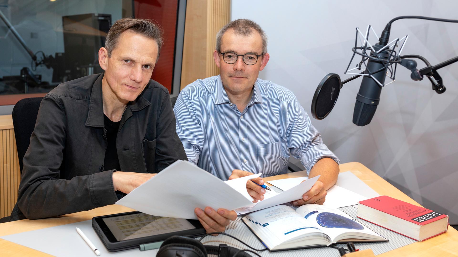 DIRK H. LORENZEN (helles Hemd), Autor der "Sternzeit,  MARKUS SCHEUMANN (schwarze Jacke), Sprecher der "Sternzeit", sitzen nebeneinander im Funkhaus Köln, 05.09.2023
