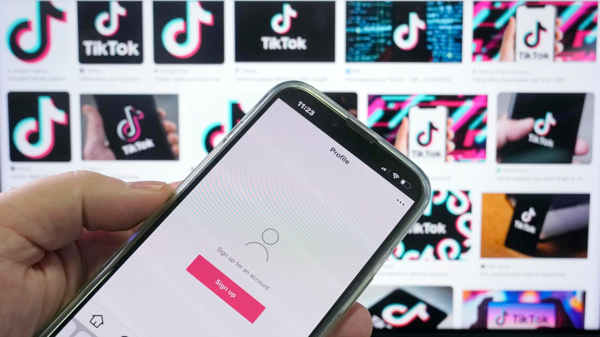 Tiktok-App auf einem Smartphone vor Werbe-Screens in Sydney, Australien