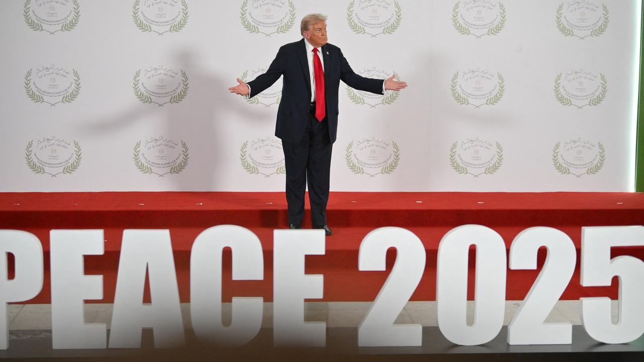 Donald Trump steht im ägyptischen Küstenort Scharm el-Scheich bei der Unterzeichnung des Abkommens für Gaza auf einer Bühne und breitet die Arme aus. Am Fuß der Bühne ist "Peace 2025" zu lesen. 