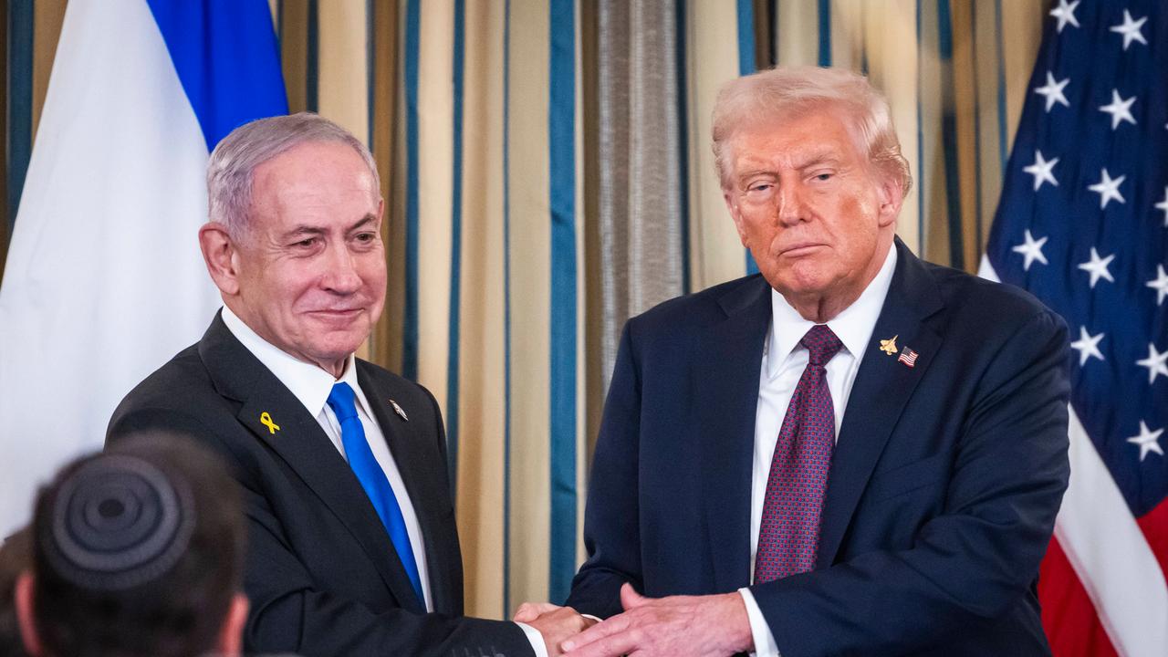 Benjamin Netanjahu (links) und Dobnald Trump (rechts) geben sich die Hände. Netanjahu schaut mit einem Lächeln in die Kameras, Trump schaut nachdenklich auf den Boden