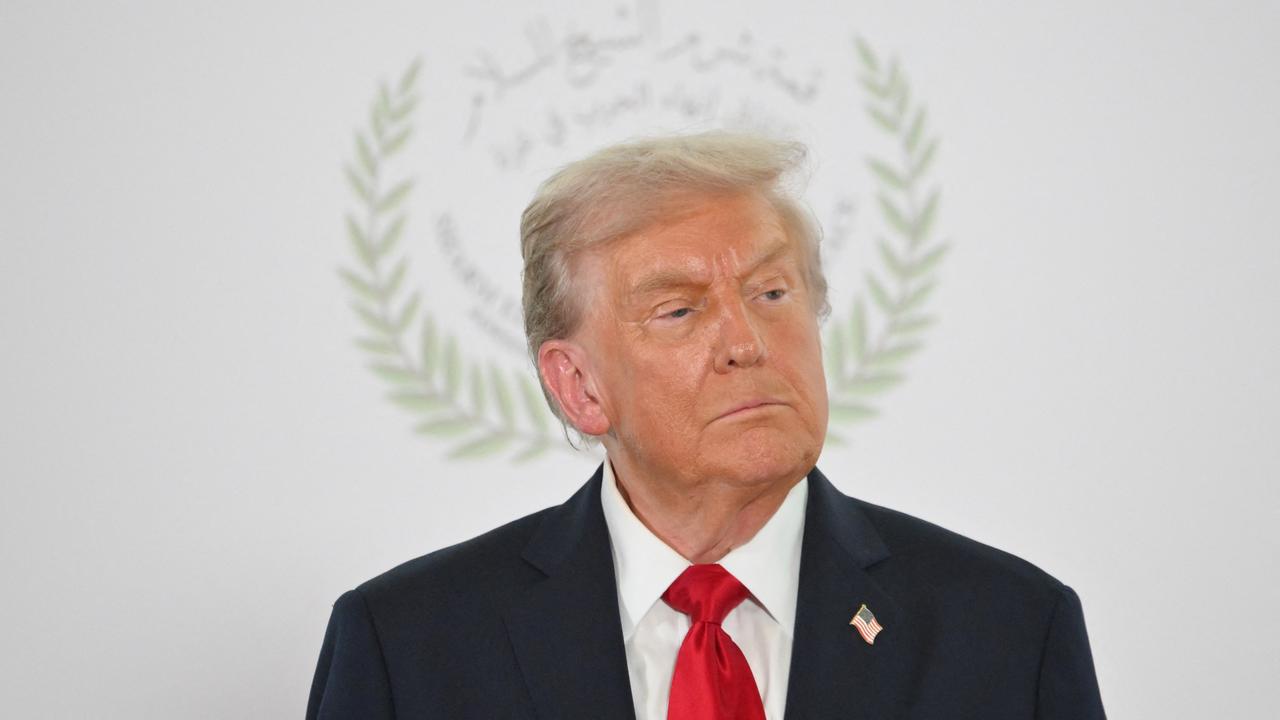 US-Präsident Donald Trump posiert beim Gaza-Friedensgipfel in Scharm el-Scheich für ein Foto. Im Hintergrund ist das Logo des Gipfels zu sehen, das seinen Kopf umrahmt.