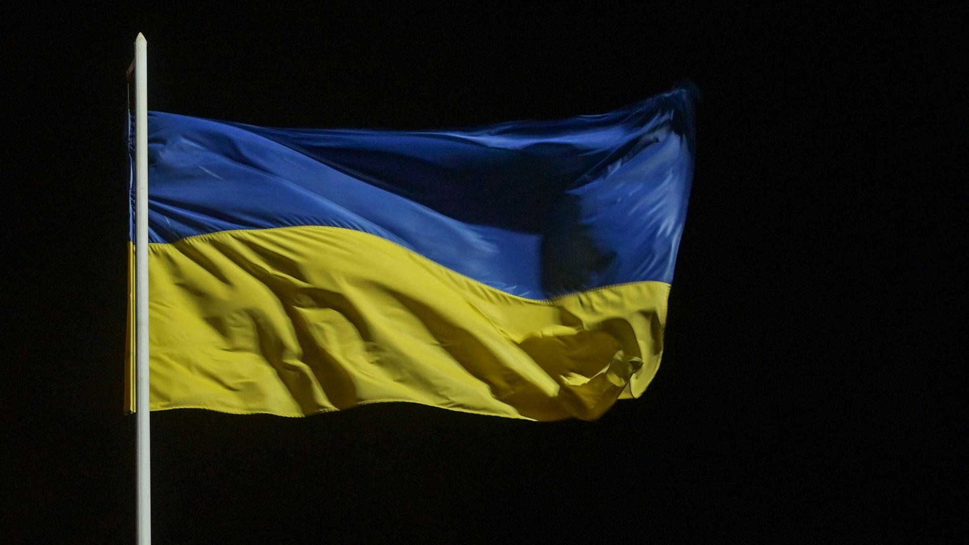 Eine blau-gelbe Flagge der Ukraine weht im Wind.