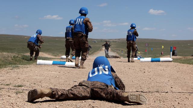 Blauhelmsodaten in der Mongolei üben in einer weiten staubigen Landschaft die Sicherung einer Straße.