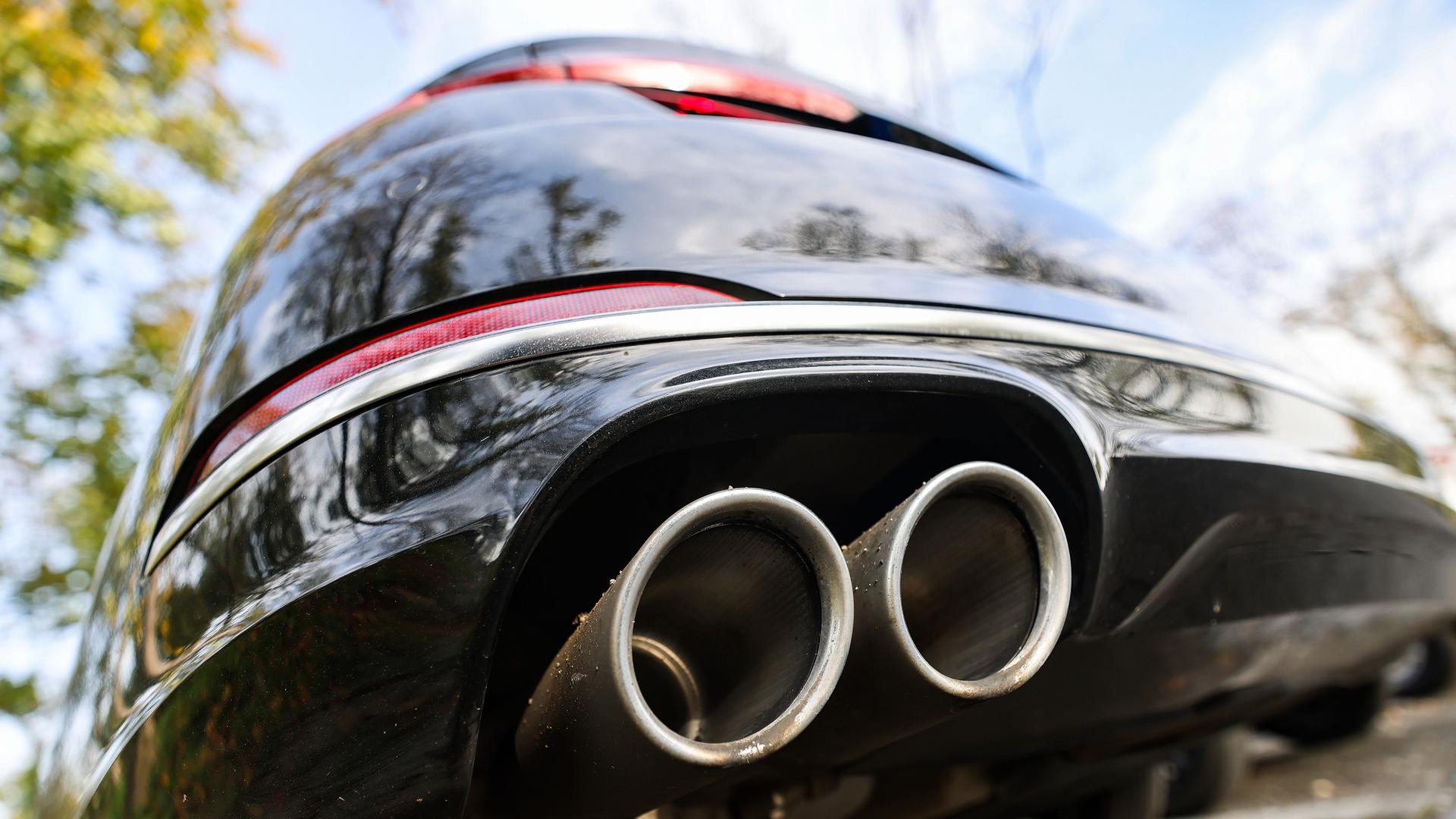 Ein Pkw mit doppeltem Auspuff steht auf einem Parkplatz. 