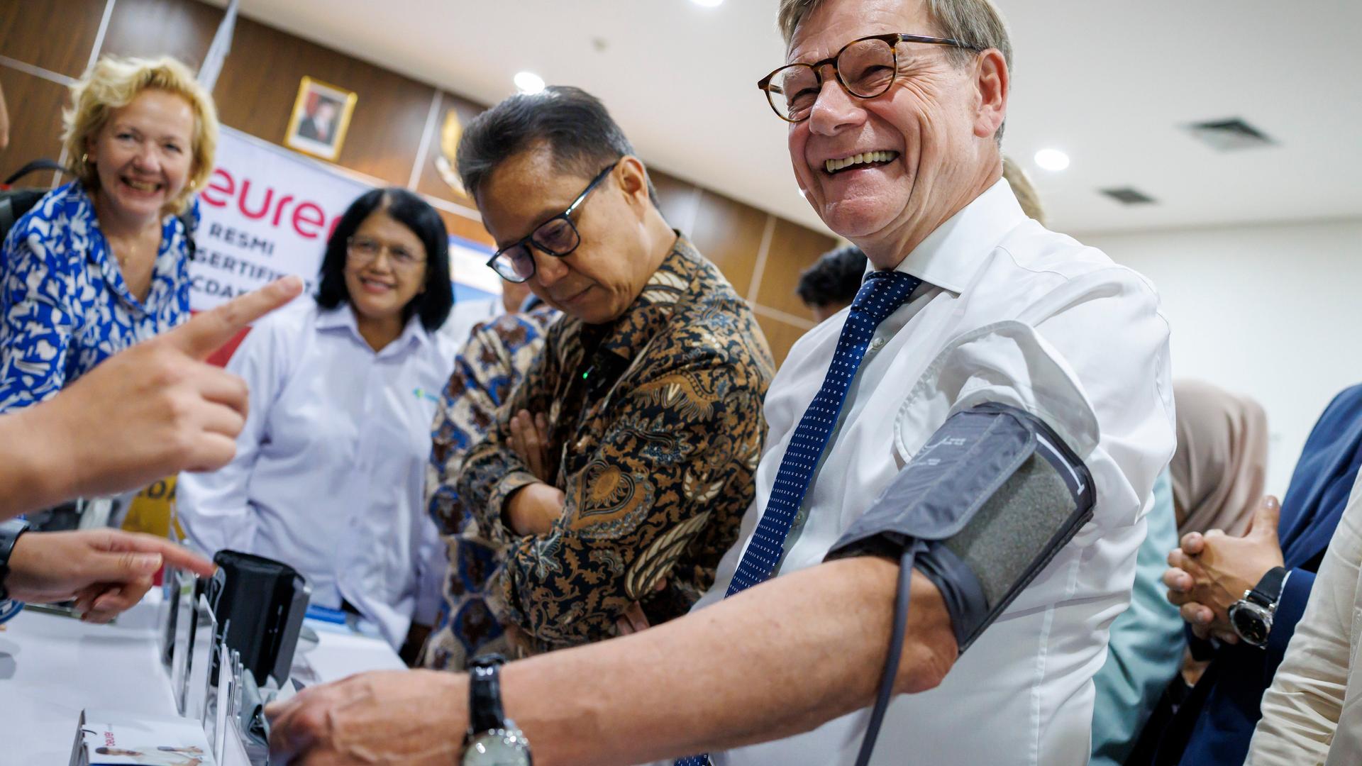 Bundesaußenminister Johann Wadephul (CDU) lässt sich den Puls messen und lacht dabei: Bei einem Besuch der staatlichen Fachhochschule für Gesundheitsberufe in Jakarta, Indonesien.