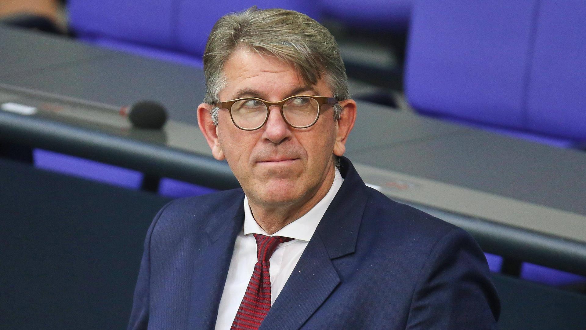 Wolfram Weimer steht im Sitzungssaal des Deutschen Bundestages und blickt gespannt zur Seite.